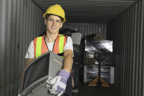 Workers loading bulky items into a tipper during a mid-job